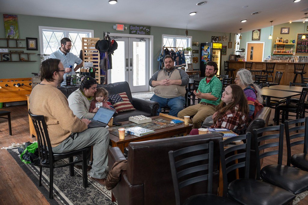 A group of people sit around a table having a discussion.